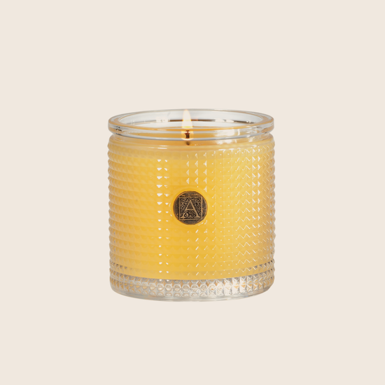 The Agave Pineapple Textured Glass Candle has a lush, fruity floral blend of pineapples and rosewood paired with sweet agave and jasmine fragrance. Our candles are all hand-poured in Arkansas. Made with a proprietary wax blend, ethically sourced containers and cotton wicks. Light one of these aromatic candles and transport yourself to a memory or emotion. 