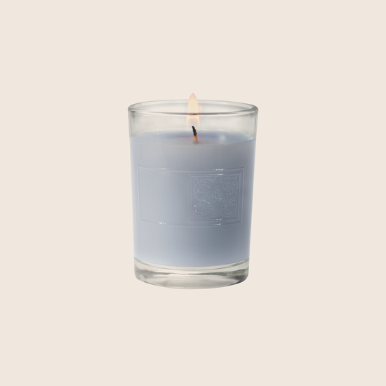 Load image into Gallery viewer, The Viola Driftwood Votive Candle conjures an oceanside scene with a calm, watery fragrance of violet leaves paired with cedar, vetiver, and infused citrus. Our candles are all hand-poured in Arkansas. Made with a proprietary wax blend, ethically sourced containers and cotton wicks. Light one of these aromatic candles and transport yourself to a memory or emotion. 
